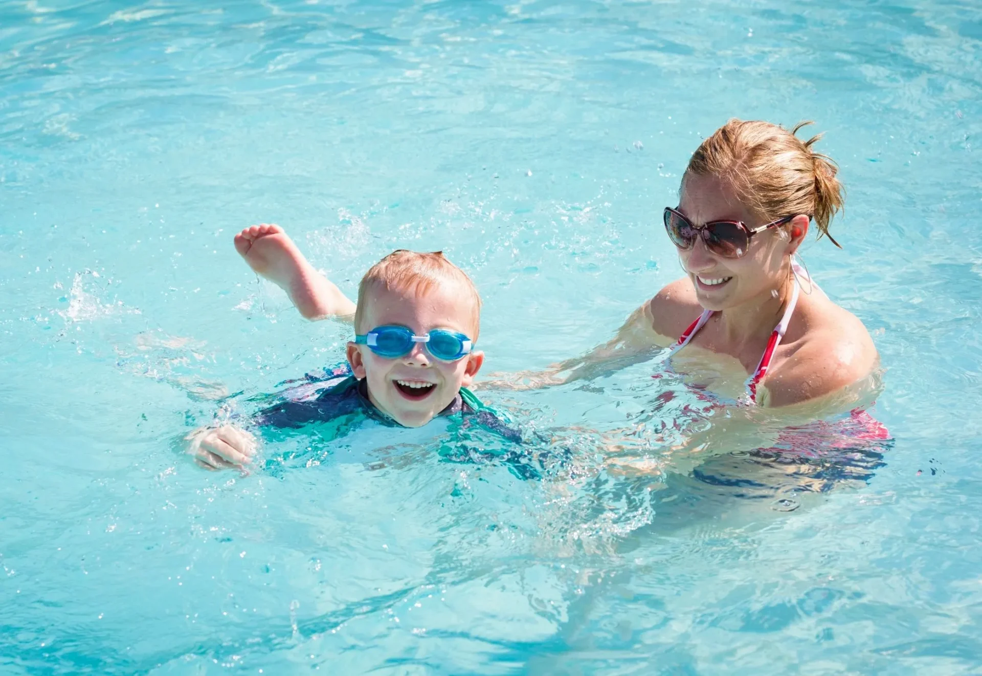 A woman and child swimming in the pool.