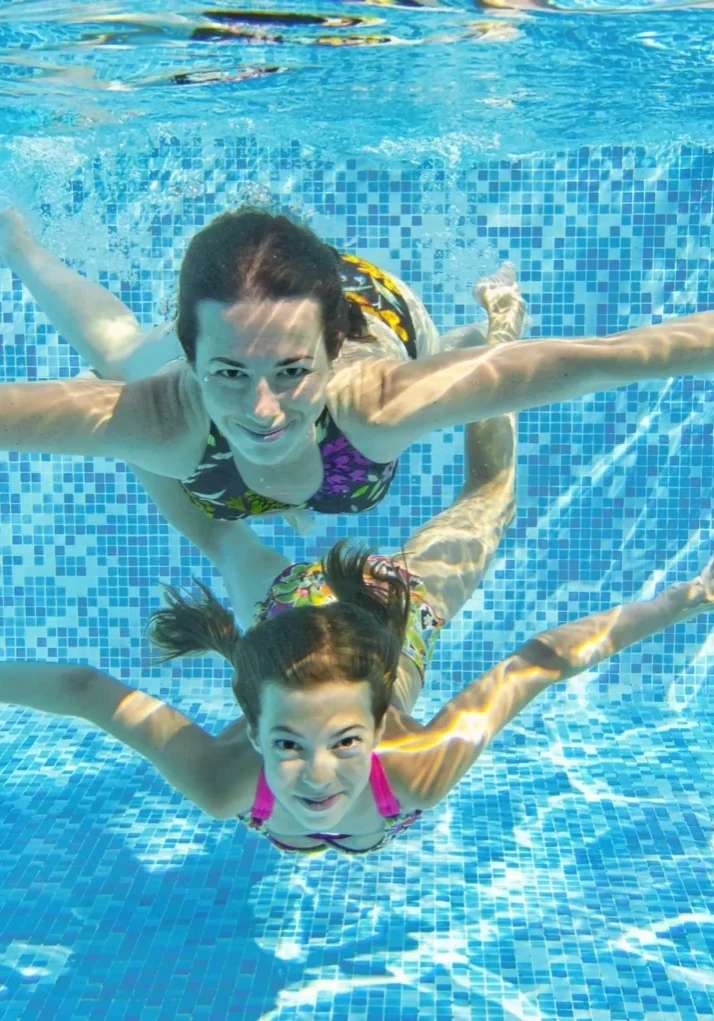 A woman and child swimming in the pool.