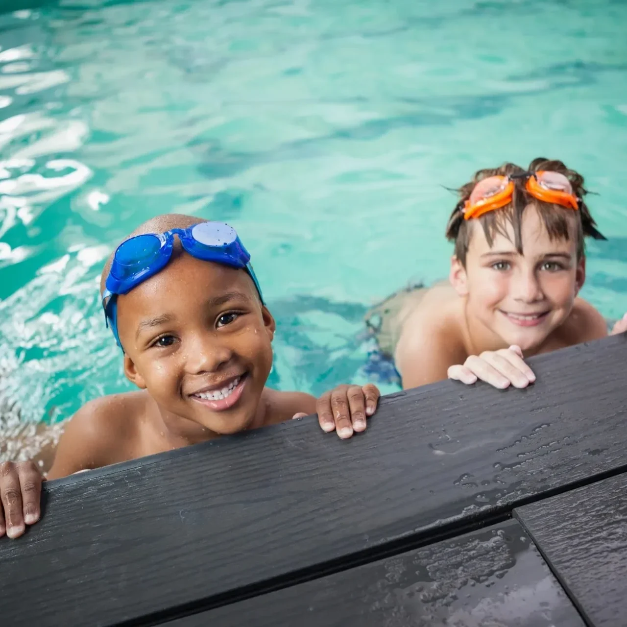 Two children in a pool with goggles on